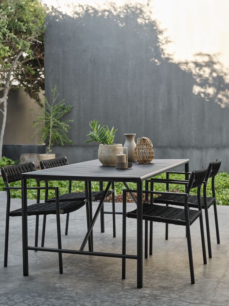 Mesa de exterior negra con 4 sillas trenzadas