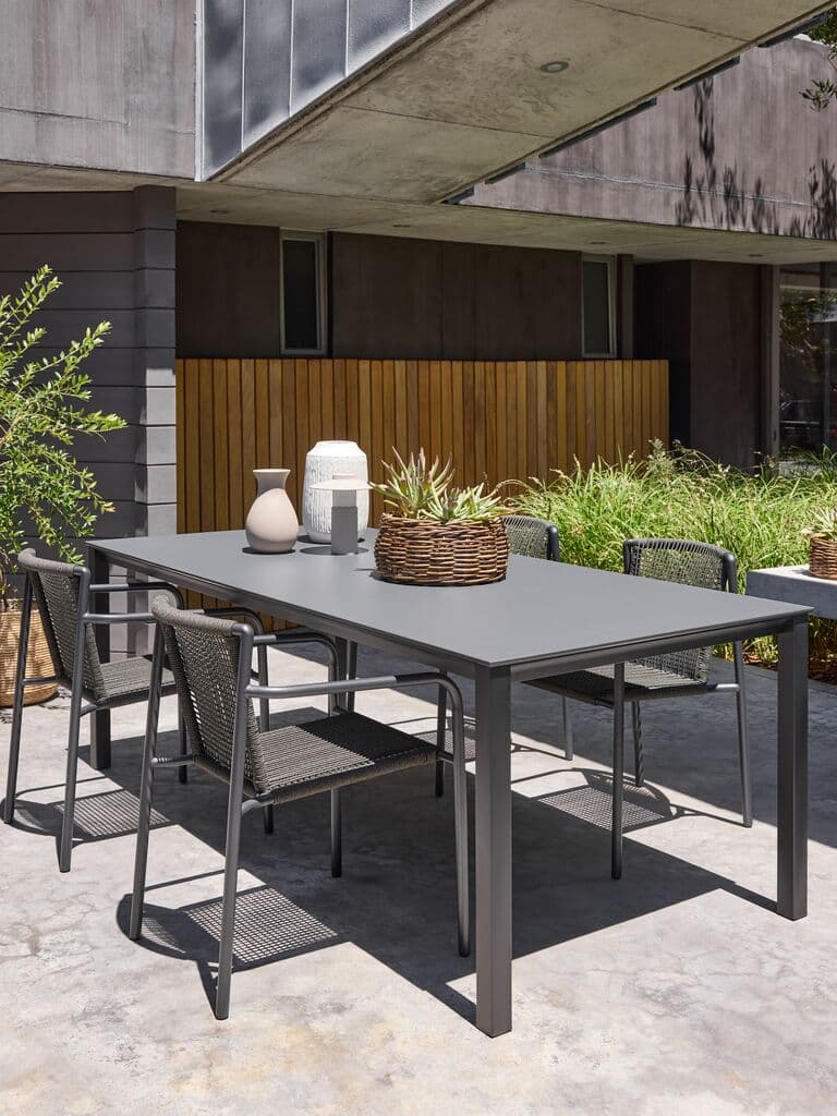 Mesa de comedor rectangular gris con sillas de cuerda