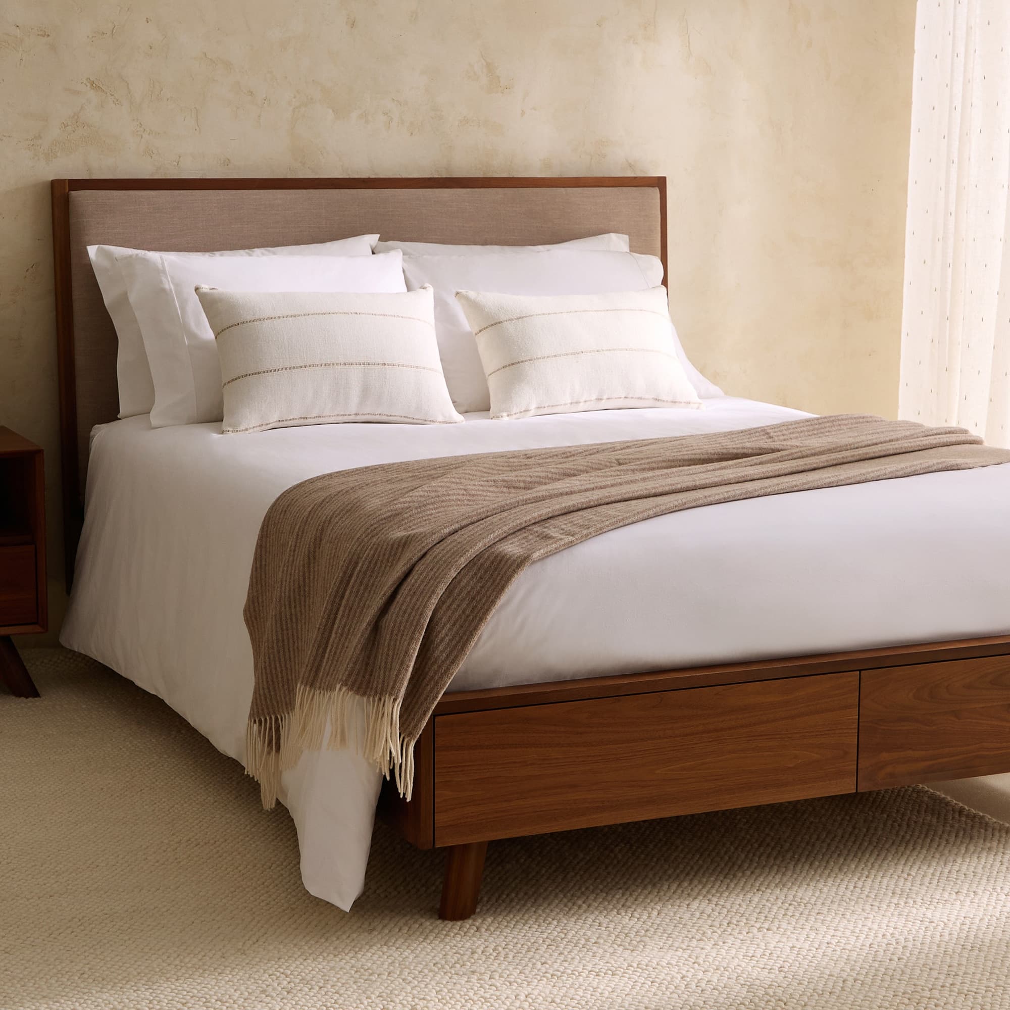 Cama doble de madera de nogal con cabecero tapizado