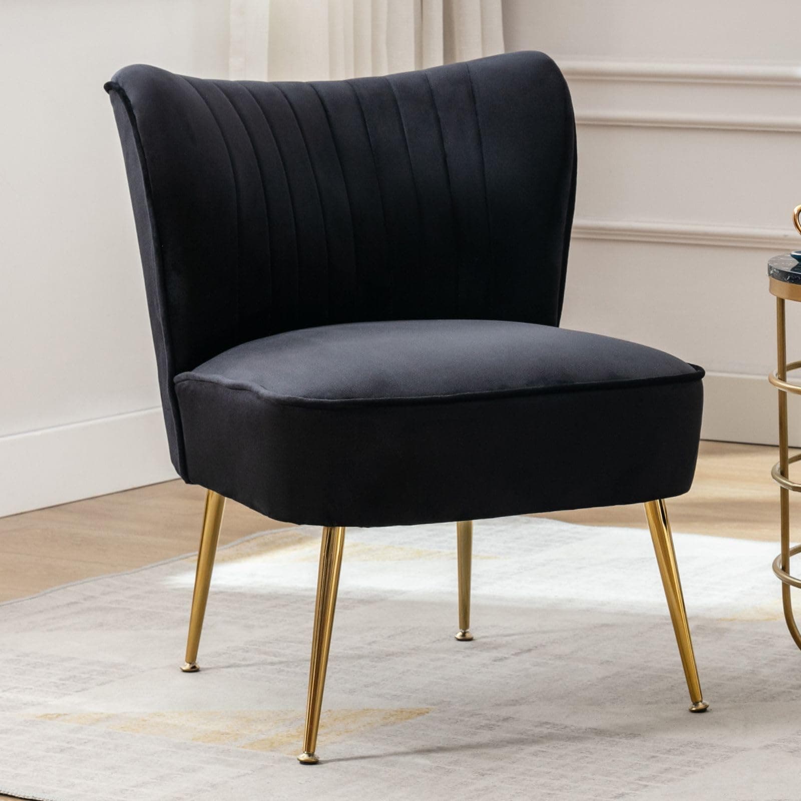 Sillón moderno tapizado en terciopelo negro con patas doradas