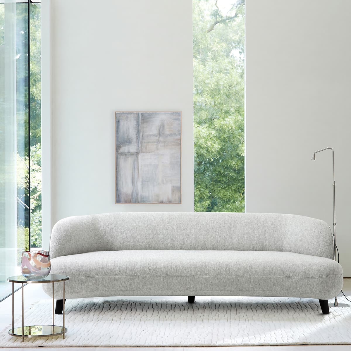 Sofá curvo tapizado en gris claro