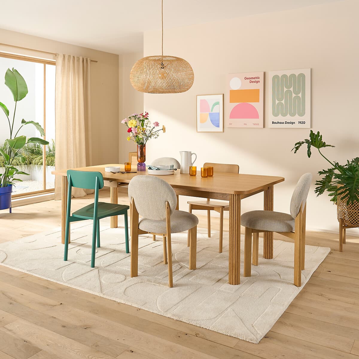 Mesa de comedor rectangular de madera clara con sillas de diseño