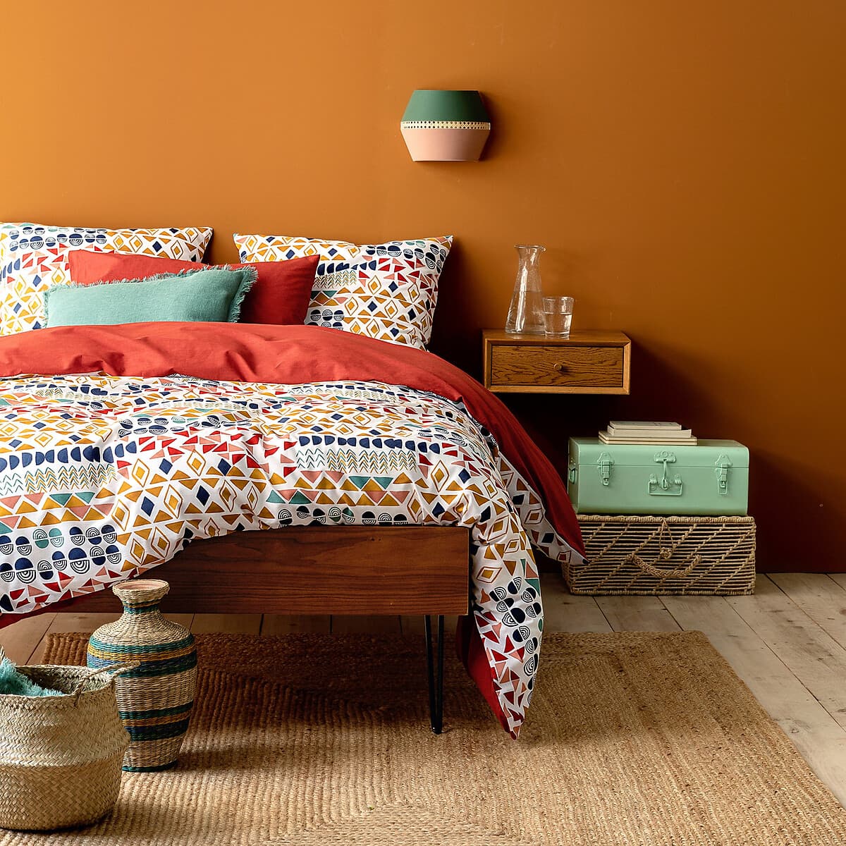 Cama de madera con ropa de cama estampada geométrica