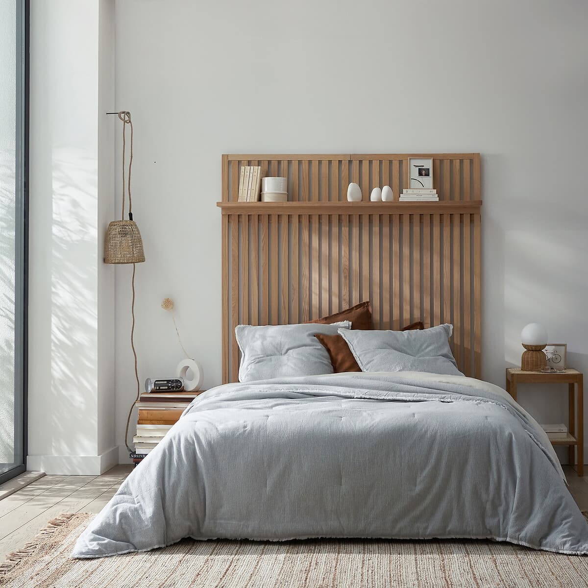 Cama de madera clara con cabecero de listones