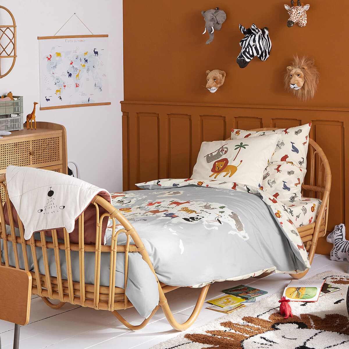 Cama infantil de ratán con ropa de cama estampada