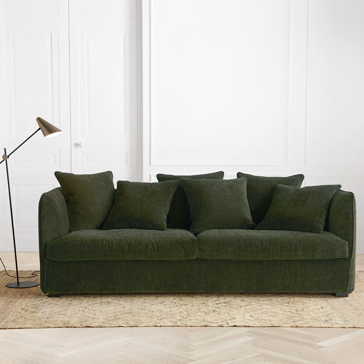 Sofá de pana verde oscuro con cojines