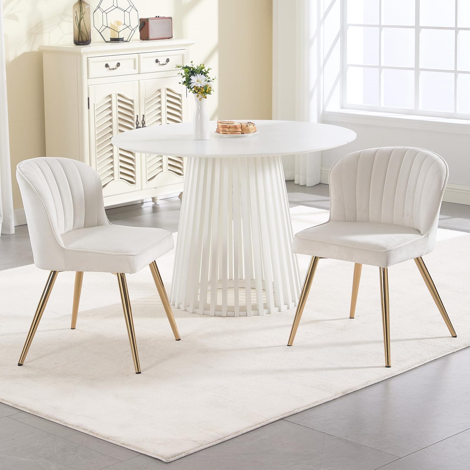 Silla de comedor tapizada en terciopelo blanco con patas doradas